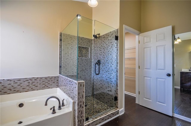 bathroom with hardwood / wood-style flooring and separate shower and tub