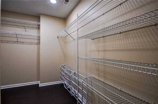 spacious closet with dark hardwood / wood-style floors