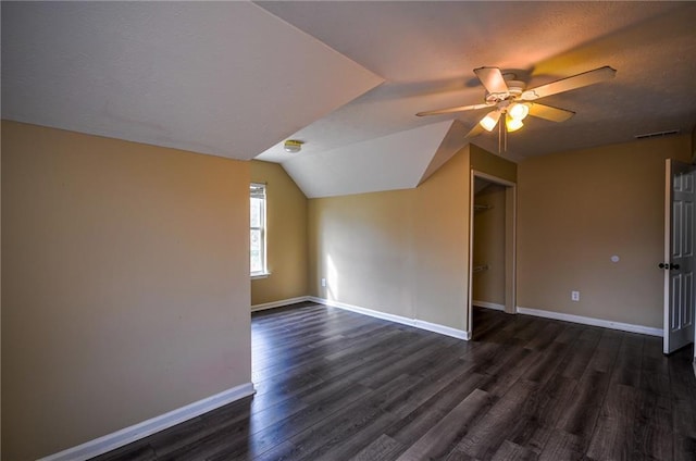 additional living space featuring dark hardwood / wood-style flooring, lofted ceiling, and ceiling fan