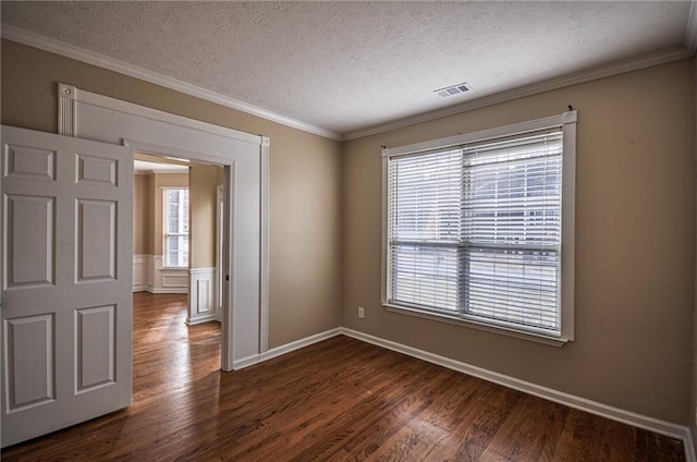 empty room featuring ornamental molding, dark wood-type flooring, and a textured ceiling