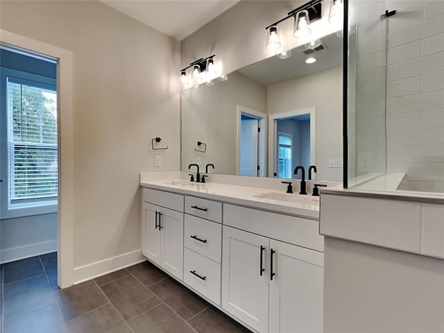 full bathroom with tile patterned flooring, visible vents, baseboards, double vanity, and a sink