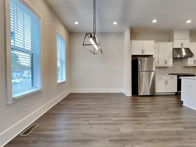 kitchen featuring wood finished floors, visible vents, baseboards, appliances with stainless steel finishes, and under cabinet range hood