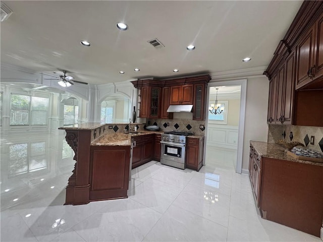 1417 Wind Chime Ct, Lawrenceville, GA 30045 - kitchen featuring high end stainless steel range, a peninsula, a ceiling fan, tasteful backsplash, and under cabinet range hood