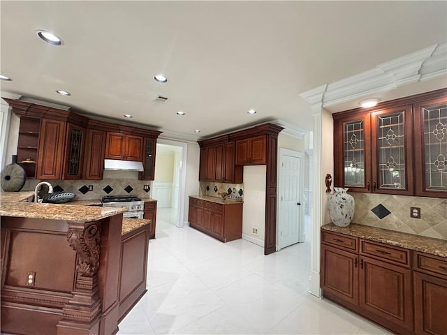 1417 Wind Chime Ct, Lawrenceville, GA 30045 - kitchen featuring under cabinet range hood, high end stainless steel range, decorative backsplash, light stone counters, and a peninsula