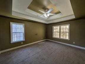 spare room featuring baseboards, a raised ceiling, and ceiling fan