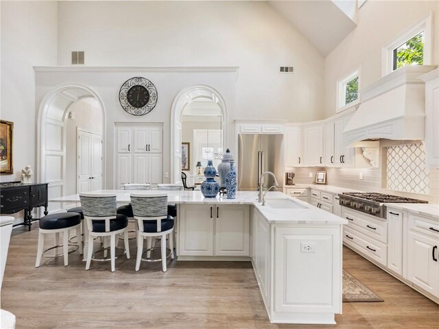 5964 Chickasaw Ln, Braselton, GA 30517 - kitchen with custom range hood, high vaulted ceiling, a sink, visible vents, and appliances with stainless steel finishes