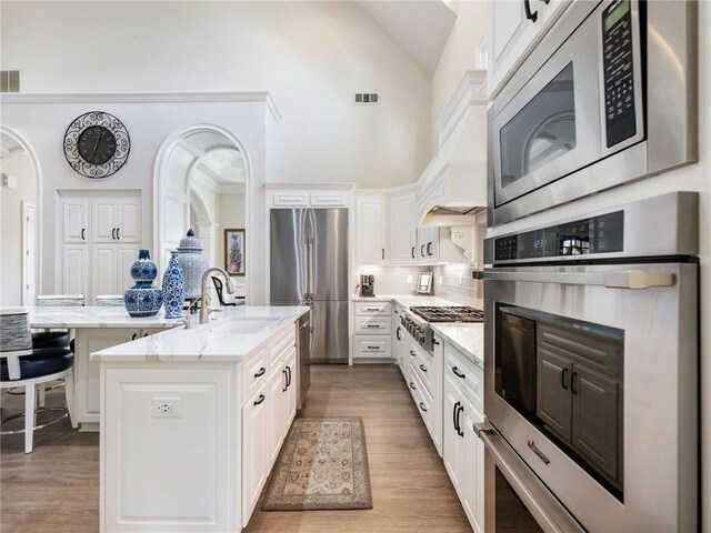 5964 Chickasaw Ln, Braselton, GA 30517 - kitchen featuring white cabinets, visible vents, a kitchen island with sink, stainless steel appliances, and a sink
