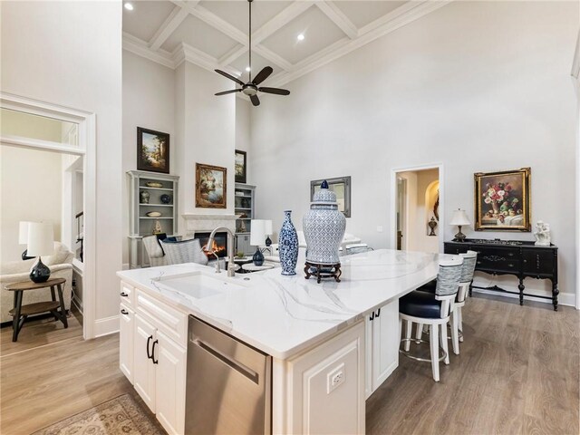 5964 Chickasaw Ln, Braselton, GA 30517 - kitchen with open floor plan, a lit fireplace, a center island with sink, a sink, and dishwasher