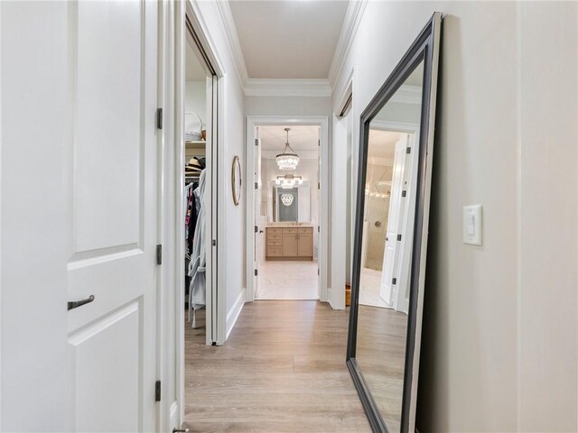 5964 Chickasaw Ln, Braselton, GA 30517 - hallway featuring an inviting chandelier, ornamental molding, baseboards, and light wood finished floors