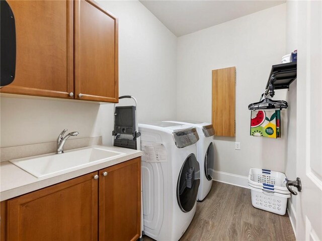 5964 Chickasaw Ln, Braselton, GA 30517 - laundry room with washing machine and clothes dryer, baseboards, wood finished floors, a sink, and cabinet space