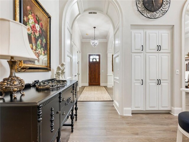 5964 Chickasaw Ln, Braselton, GA 30517 - foyer entrance featuring arched walkways, crown molding, baseboards, and light wood-type flooring