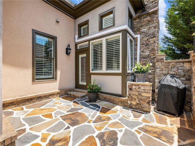 5964 Chickasaw Ln, Braselton, GA 30517 - view of exterior entry with stucco siding, stone siding, and a patio