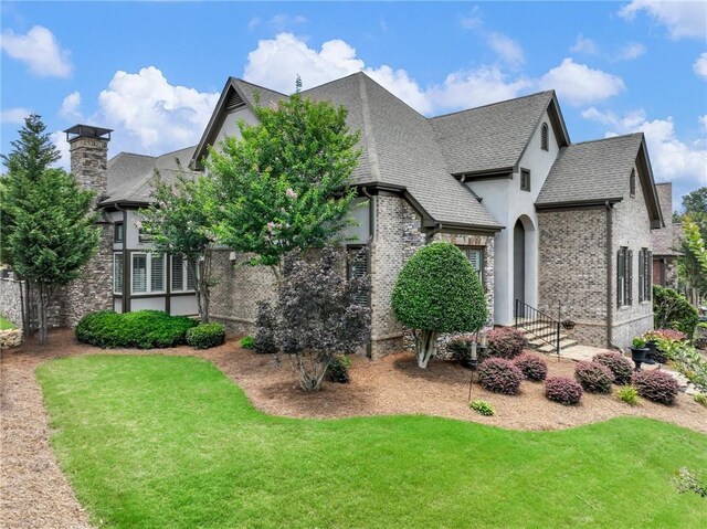 5964 Chickasaw Ln, Braselton, GA 30517 - view of front of property with a chimney, stucco siding, roof with shingles, and a front lawn