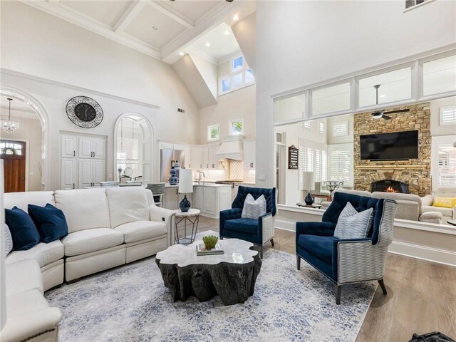 5964 Chickasaw Ln, Braselton, GA 30517 - living area featuring coffered ceiling, ceiling fan with notable chandelier, light wood-style floors, beamed ceiling, and a fireplace