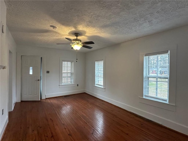 entrance foyer featuring ceiling fan, a textured ceiling, baseboards, and dark wood-style flooring