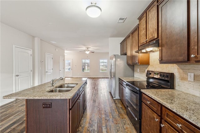 kitchen featuring dark hardwood / wood-style floors, tasteful backsplash, sink, a kitchen island with sink, and electric range