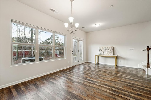 empty room with dark hardwood / wood-style flooring and a chandelier