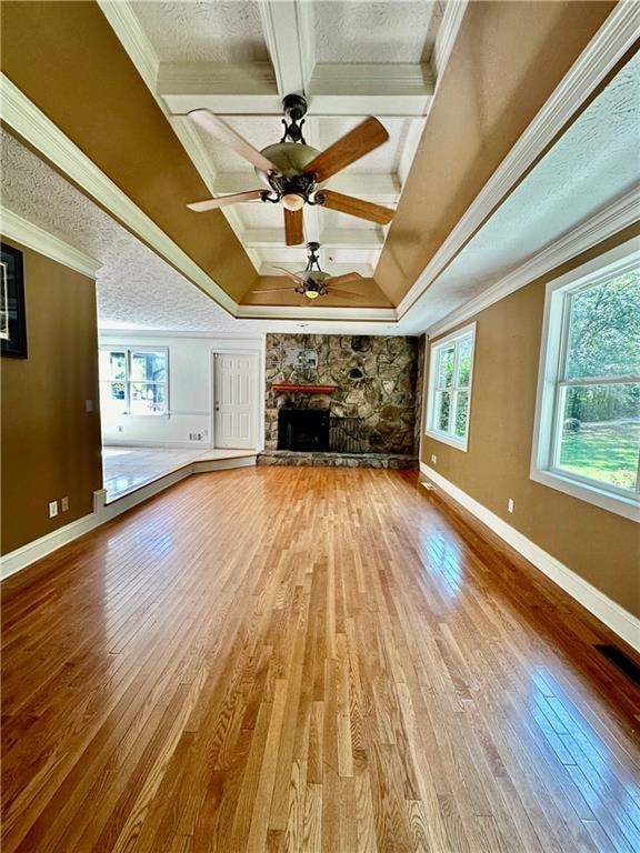 unfurnished living room featuring a fireplace, ornamental molding, hardwood / wood-style floors, and ceiling fan