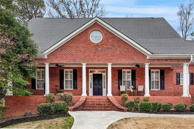 view of front of house with a porch, roof with shingles, brick siding, and ceiling fan