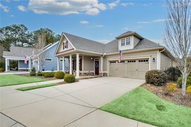 view of front facade with an attached garage, covered porch, a shingled roof, concrete driveway, and a front lawn