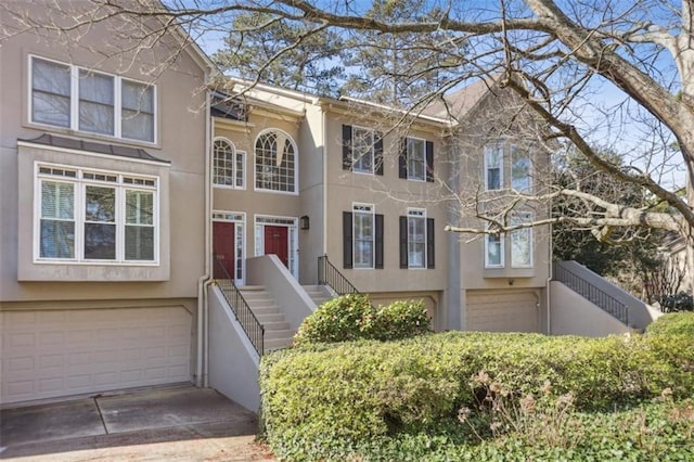 townhome / multi-family property featuring stucco siding, driveway, and an attached garage