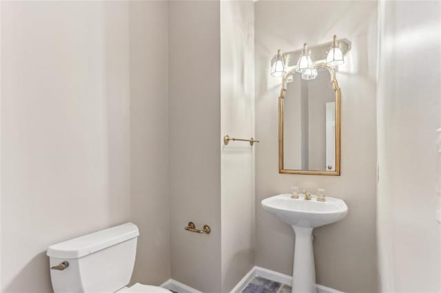 bathroom featuring toilet and baseboards