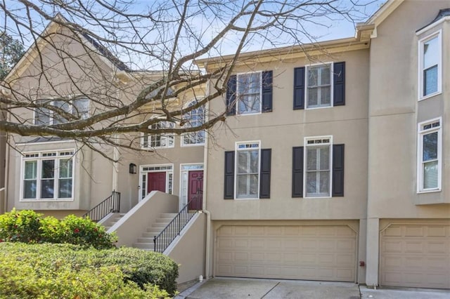 view of property featuring stucco siding, driveway, and a garage