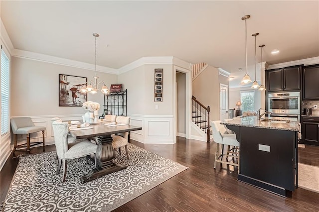 2433 Santa Rosa St, Alpharetta, GA 30009 - dining space featuring dark wood-style floors, stairway, a chandelier, a wainscoted wall, and ornamental molding