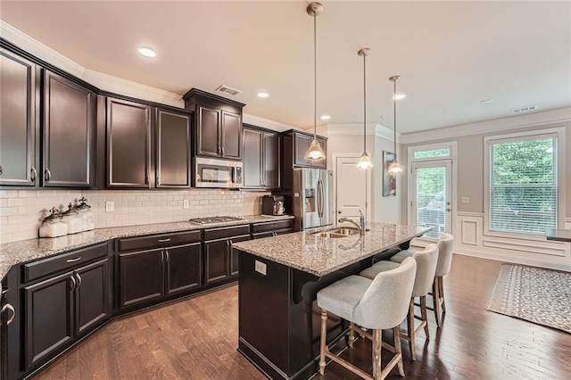 2433 Santa Rosa St, Alpharetta, GA 30009 - kitchen featuring appliances with stainless steel finishes, a breakfast bar, crown molding, light stone counters, and wood finished floors