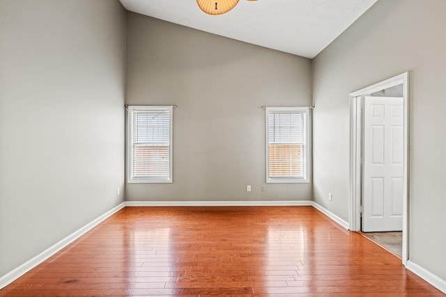 unfurnished room with hardwood / wood-style floors, a wealth of natural light, and baseboards