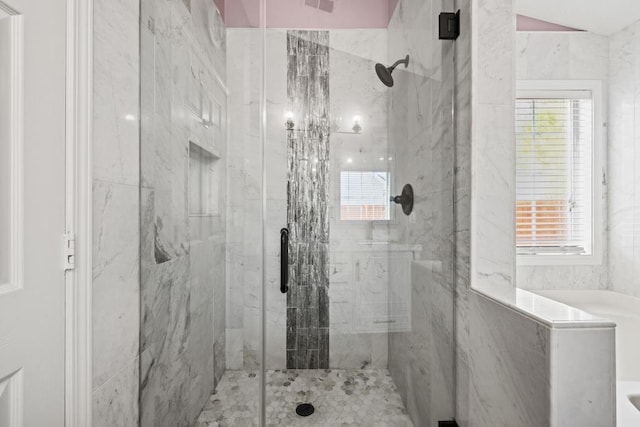 bathroom with a marble finish shower and visible vents