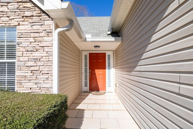 entrance to property featuring a shingled roof