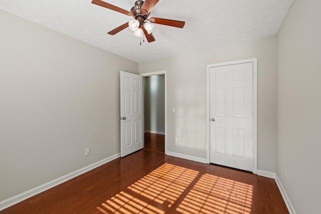 unfurnished bedroom featuring ceiling fan, baseboards, and wood finished floors