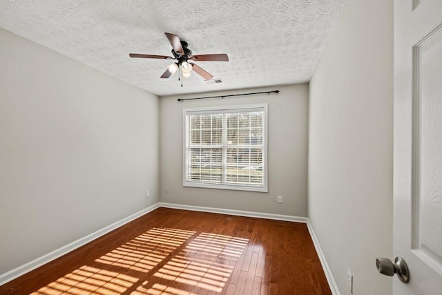 empty room featuring visible vents, baseboards, wood-type flooring, ceiling fan, and a textured ceiling