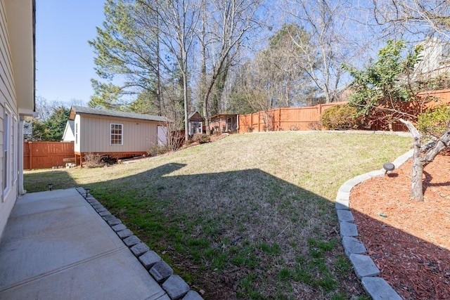 view of yard featuring a patio area, an outdoor structure, and a fenced backyard