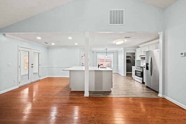 kitchen with visible vents, white cabinets, hardwood / wood-style flooring, appliances with stainless steel finishes, and light countertops