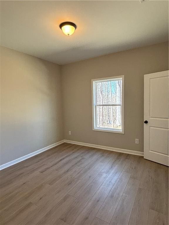 unfurnished room with light wood-style floors and baseboards