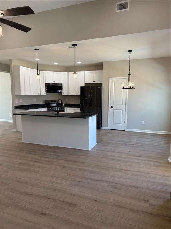 kitchen featuring visible vents, white cabinets, black fridge with ice dispenser, dark countertops, and pendant lighting