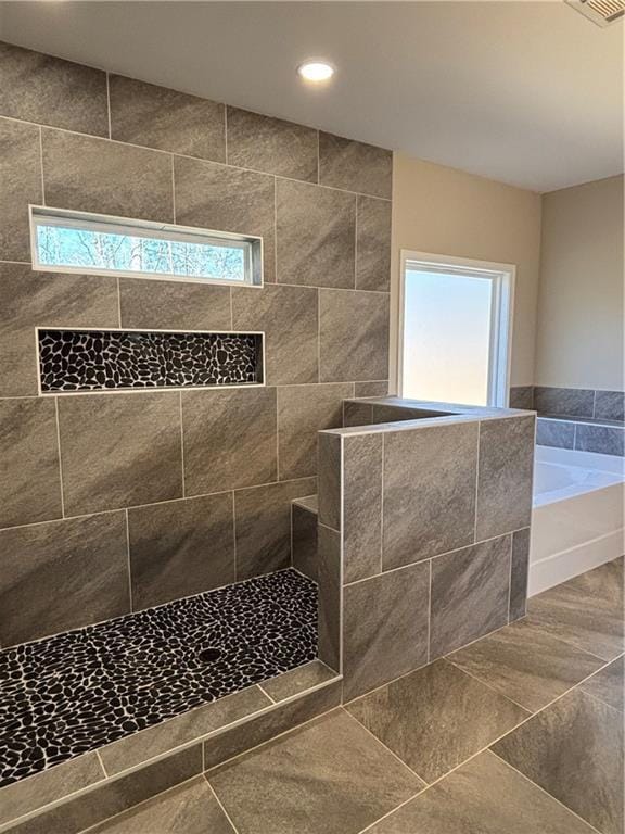 full bathroom with recessed lighting, a healthy amount of sunlight, a garden tub, and a tile shower