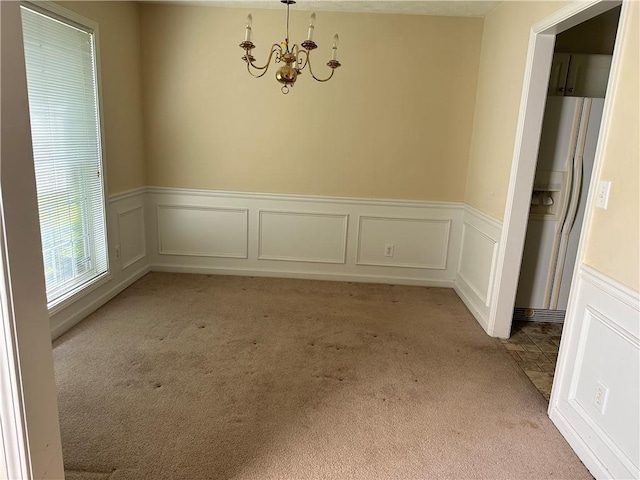 1570 Twin Bridge Ln, Lawrenceville, GA 30043 - unfurnished dining area featuring light colored carpet, a chandelier, a wainscoted wall, and a decorative wall