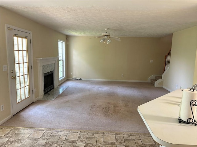 1570 Twin Bridge Ln, Lawrenceville, GA 30043 - unfurnished living room featuring a ceiling fan, a high end fireplace, baseboards, a textured ceiling, and stairway