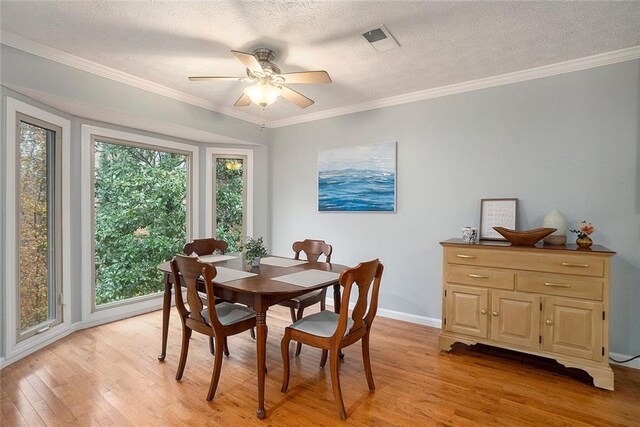 dining area with ceiling fan, crown molding, a textured ceiling, and light hardwood / wood-style flooring