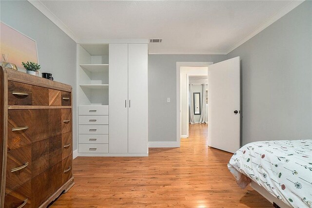 bedroom featuring crown molding and light wood-type flooring