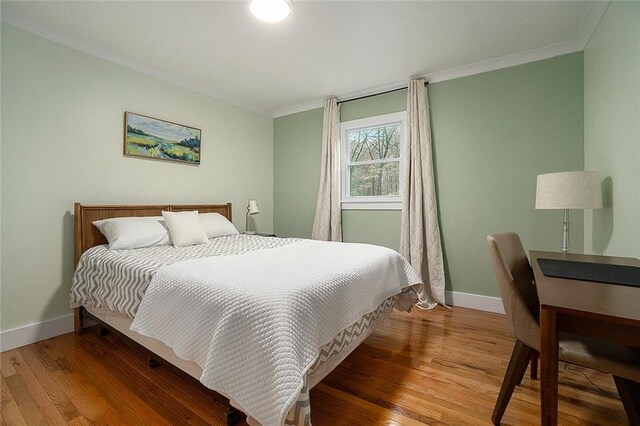 bedroom with hardwood / wood-style flooring and ornamental molding