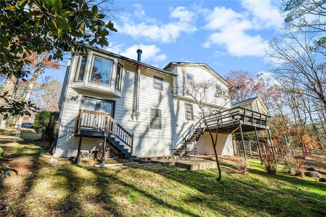 rear view of property with a lawn and a deck