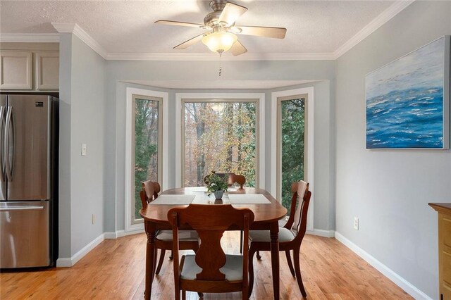 dining space with crown molding, light hardwood / wood-style flooring, ceiling fan, and a textured ceiling