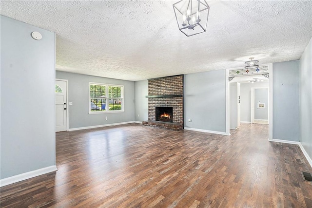 96 S Forty Pass S, Hiram, GA 30141 - unfurnished living room featuring wood finished floors, a textured ceiling, and a brick fireplace
