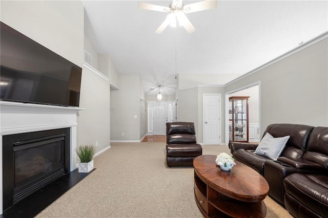 carpeted living room featuring lofted ceiling, a fireplace with flush hearth, a ceiling fan, and baseboards