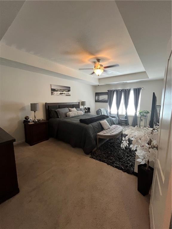 7699 Cabrini Pl, Fairburn, GA 30213 - carpeted bedroom with a raised ceiling and ceiling fan