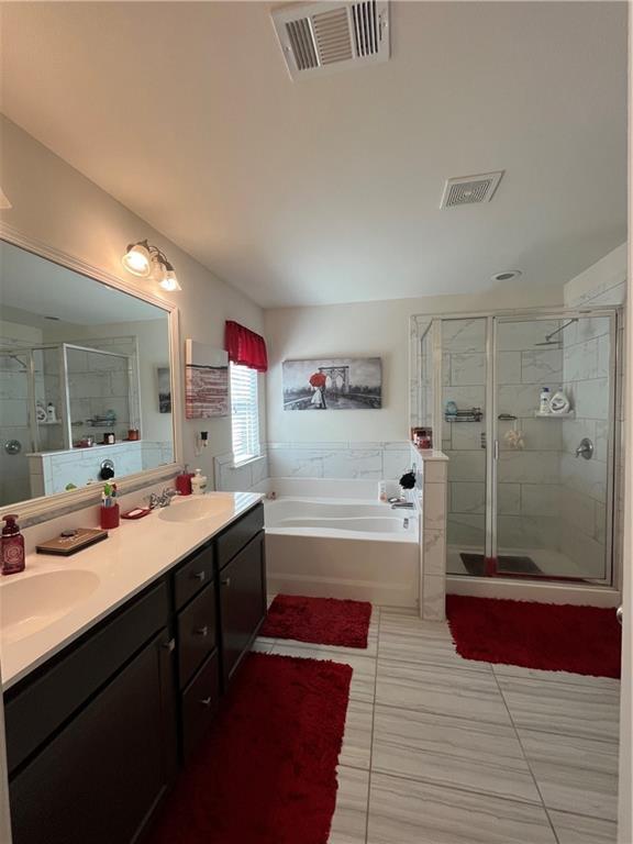 7699 Cabrini Pl, Fairburn, GA 30213 - full bathroom featuring a garden tub, a shower stall, double vanity, and tile patterned flooring